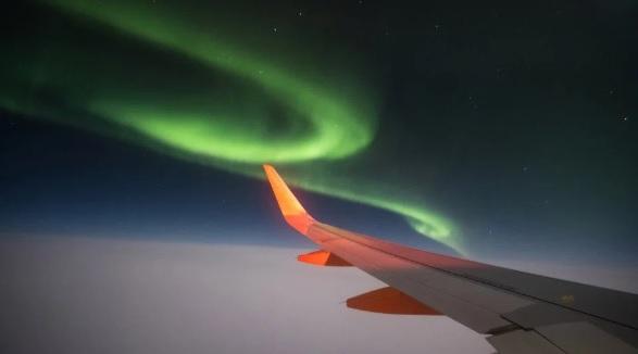 Пролетая над Исландией: пассажир заснял впечатляющее северное сияние из окна самолета