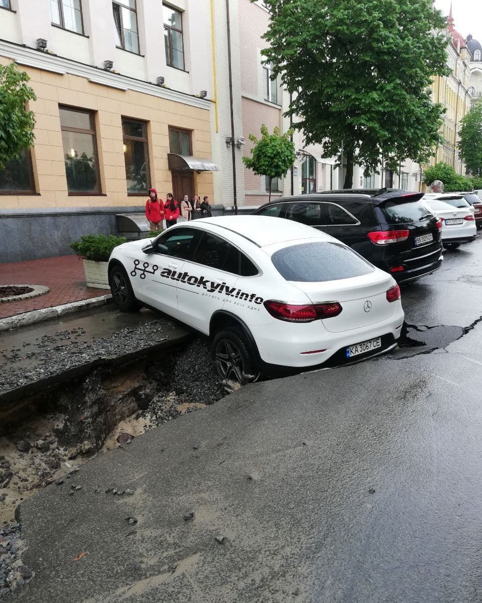 В центре Киеве после сильного дождя размыло дорогу: Мерседес провалился под асфальт